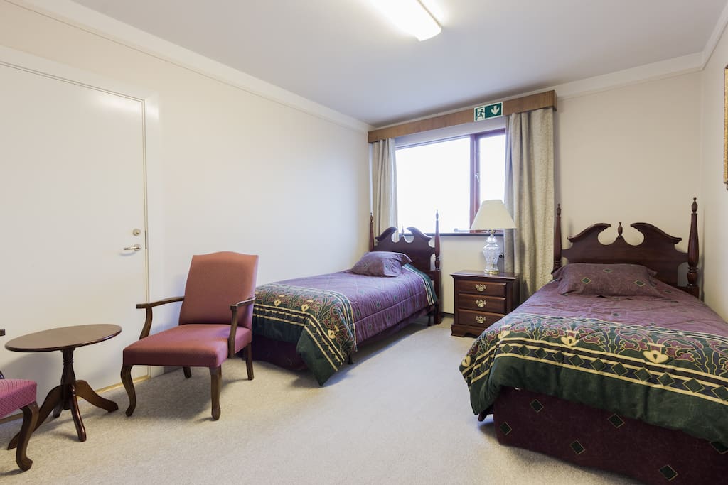 Private room with two comfortable single beds and lonunge chairs