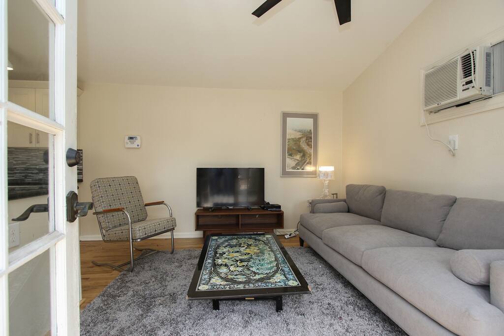 Living area with sofa, guest chair and TV
