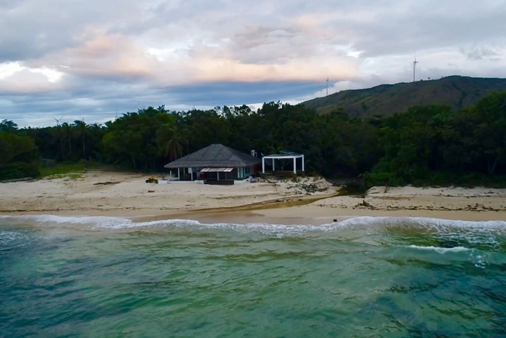 Facing the beach house. You have like a small creek where the water from the mountains come out to the sea. You have the windmills on top of the hill at the background