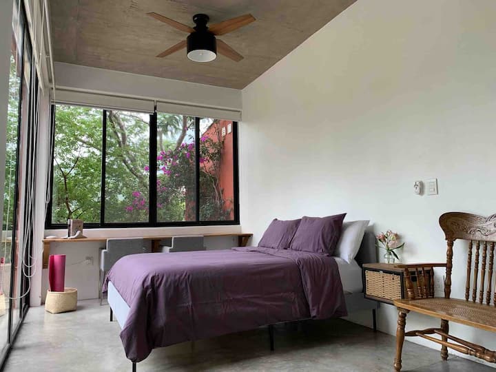 Chumba kikuu cha kulala . Ina meza yenye viti viwili ambapo unaweza kuweka kompyuta yako na   kufanya kazi na mwonekano mzuri wa bustani 