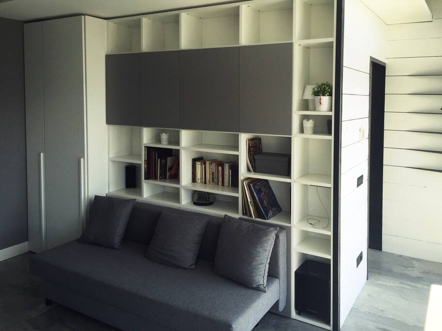 Parete attrezzata, libreria, colonna armadio, divano letto 1 piazza e mezzo. Ampie finestre terrazzo.