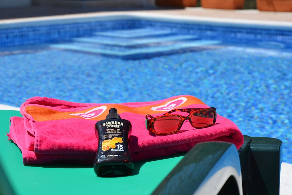 Sunbathing by the pool. Pool towels and parasols are provided.