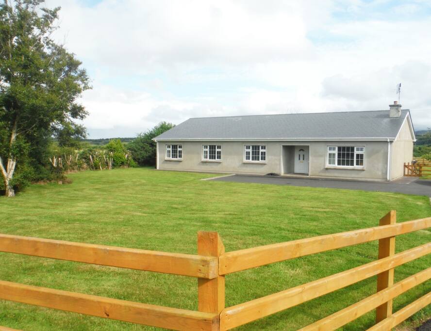Front of house with large mature garden