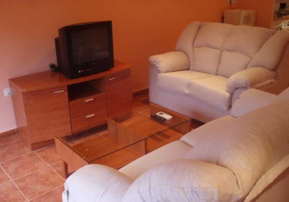 Salón con dos sofás y TV.
