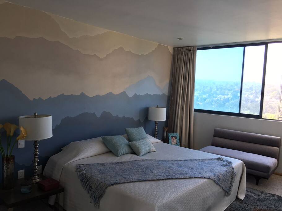 habitacion muy iluminada y calida con vista a las montañas.