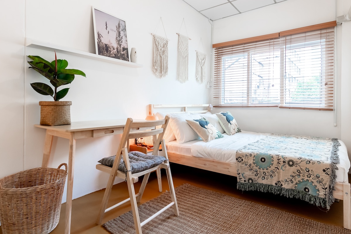 غرفة النوم الأولى بسرير بحجم كبير وطاولة عمل وكرسي. 