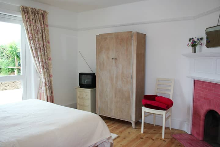 Დიდი ზომის საწოლი სამხრეთით მდებარე საძინებელში პატიოს კარით