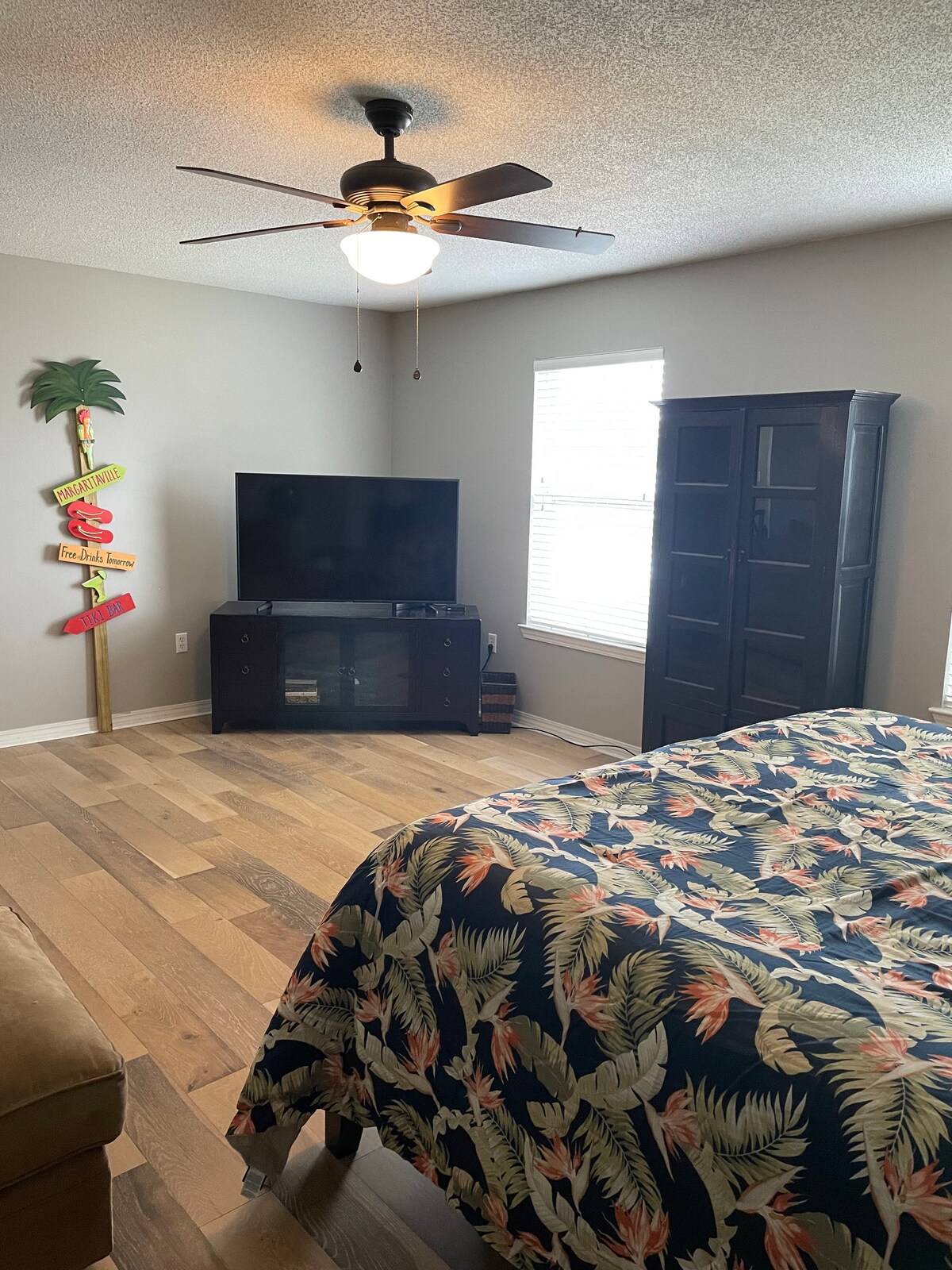 جناح رئيسي كبير بغرفة نوم مع منطقة جلوس وتلفزيون كبير