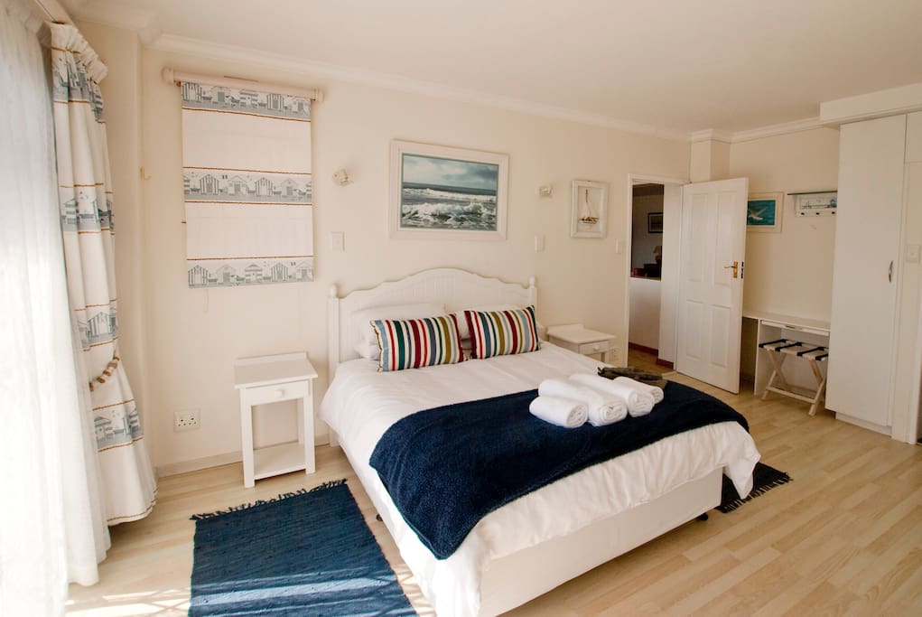 Main bedroom with double bed and en-suite bathroom with shower and bath.