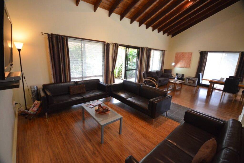 Massive Living Room with leather couches and 1-seater Norfolk Pine handmade dining room table.