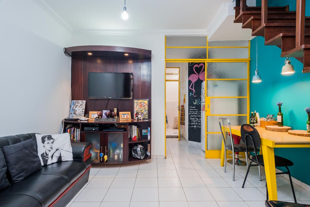 Sala com mesa de jantar e tv.