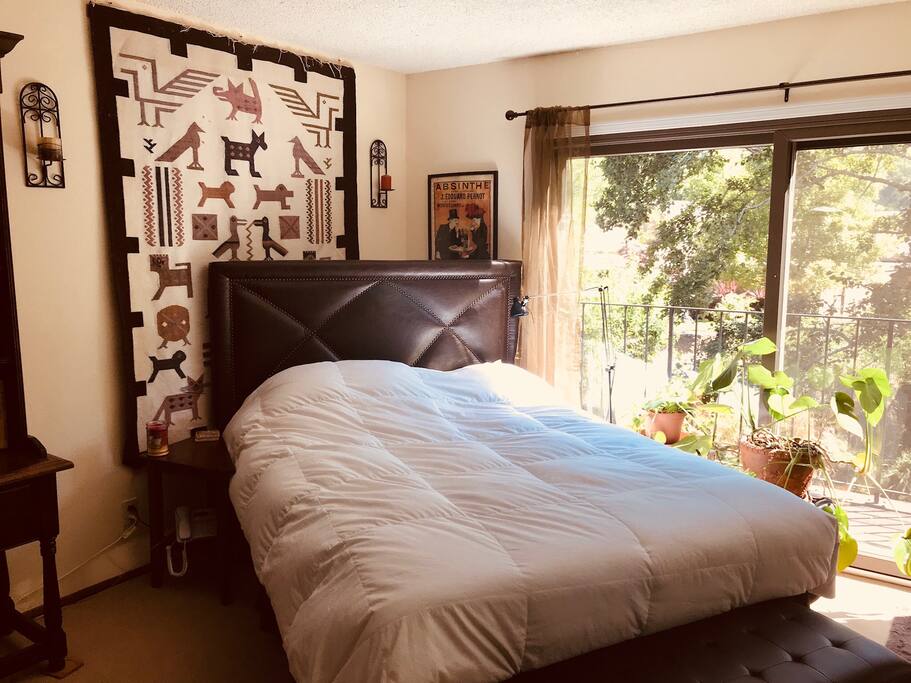 Master guestroom with large sliding glass doors to deck, and creek and tree views