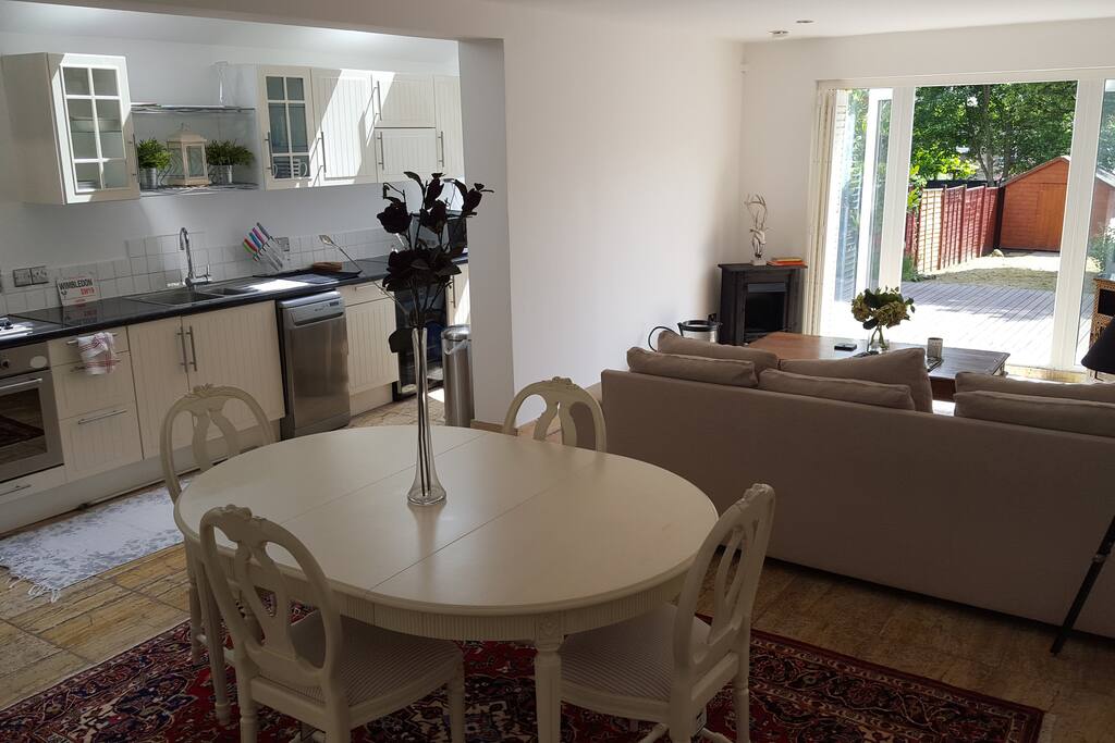 Large living room with dining table and social area facing the garden
