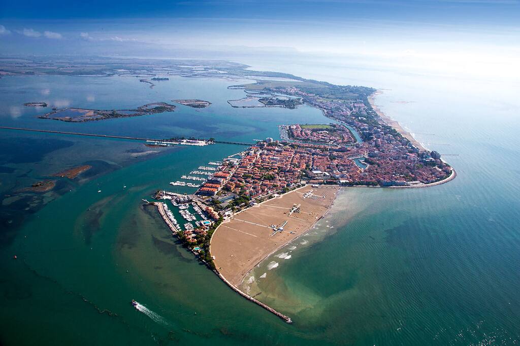 Aerial view of Grado showing lagoon, yacht mooring, city and beach