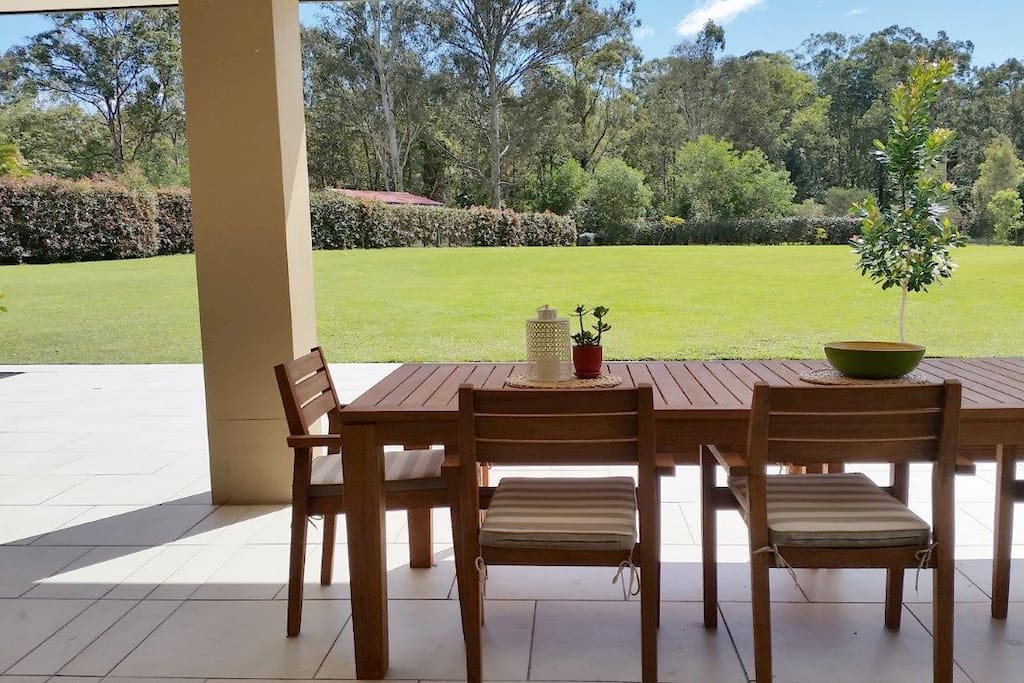 10 person outdoor dining table on the patio overlooking private level lawn and gardens