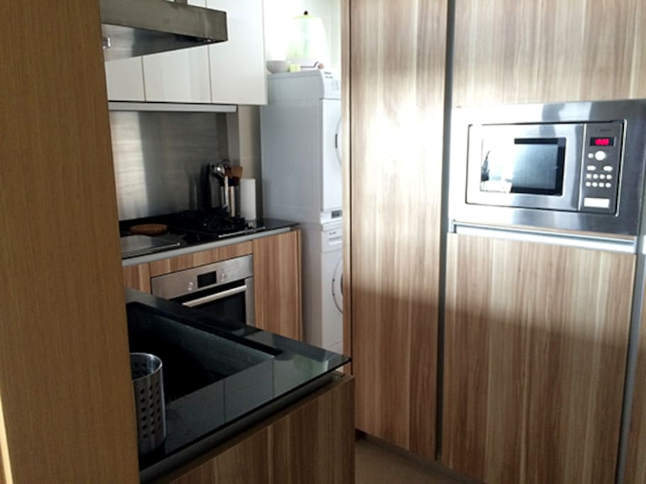 Kitchen with granite surfaces, microwave, sink, hobs and oven. Large fridge freezer is on the right out of shot.