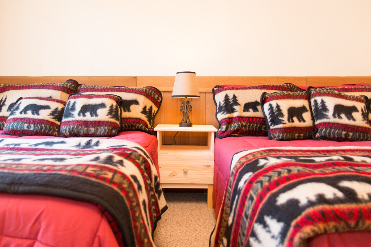 غرفة نوم مشرقة في الطابق العلوي بسريرين كاملين من سرير نيست - سرير ألكسندر المميز هجين وحب مع وسائد سهلة التنفس. مدخل منزلق إلى الشرفة المطلة على السطح الأمامي.