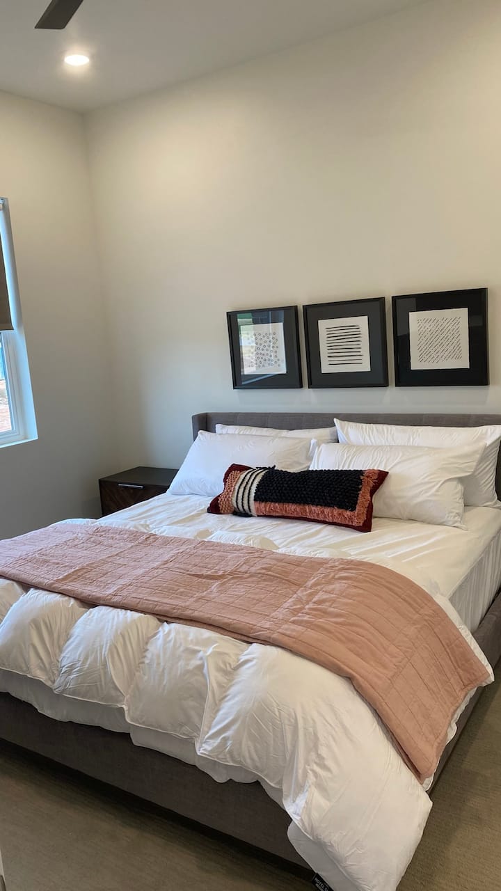 Dormitorio #3: cama tamaño king que también tiene mesita de noche, armario y TV Roku.