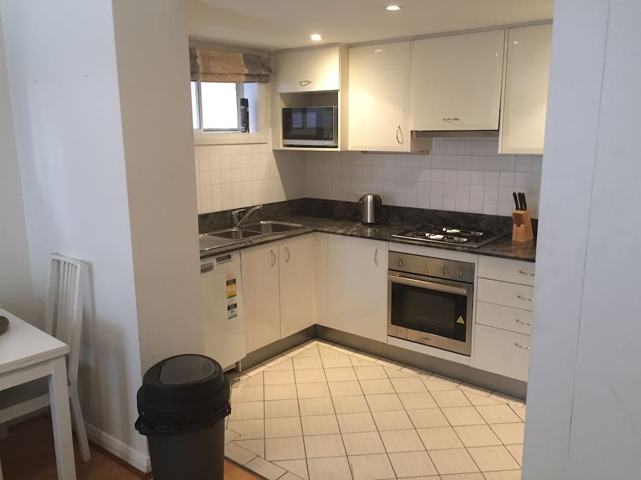 Functional modern kitchen with gas cooktop , dishwasher ,fridge freezer and all day to day kitchen appliances .