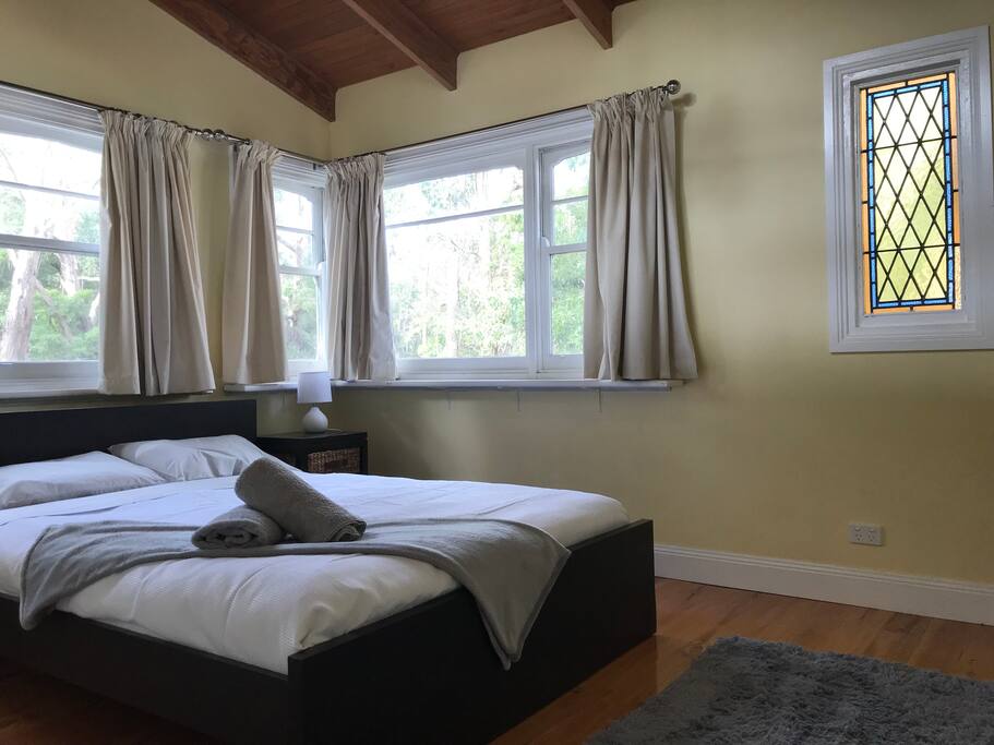 Light-filled queen bedroom with landscape views of woods
