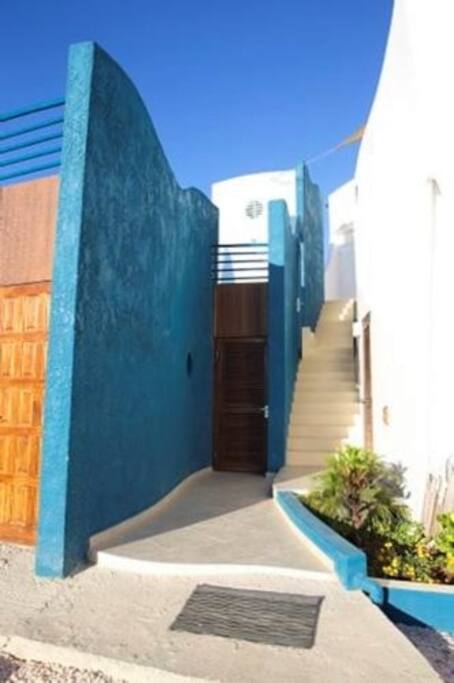 The stairs towards the shared rooftop terrace with lounge area and ocean view