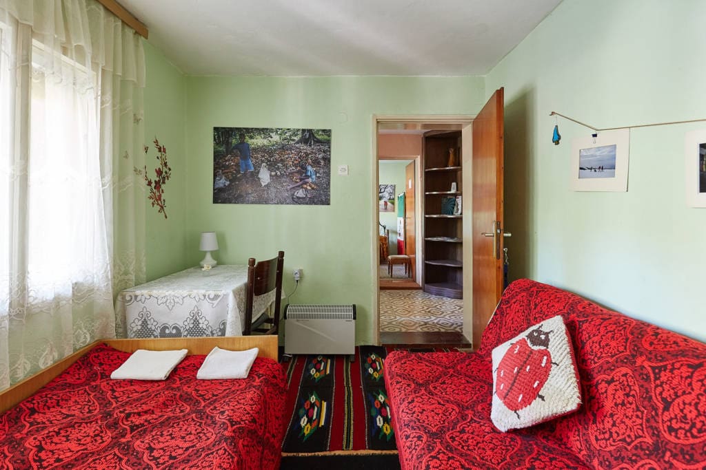 Garden view bedroom - two beds and traditional kilims on the parquet floor