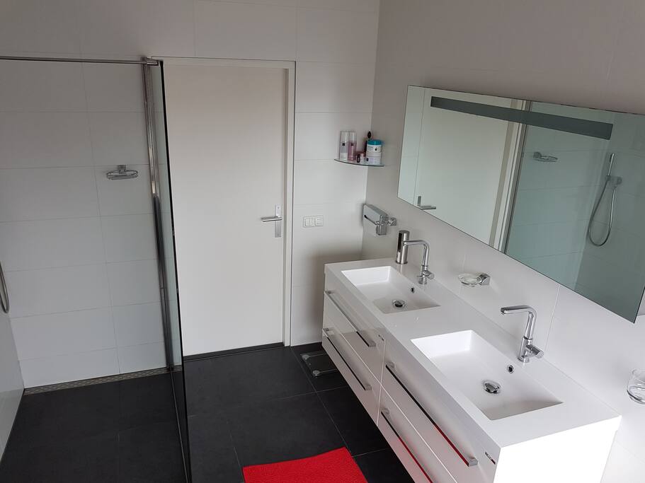 Ruime badkamer met dubbel wastafelmeubel, regendouche en bubbelbad