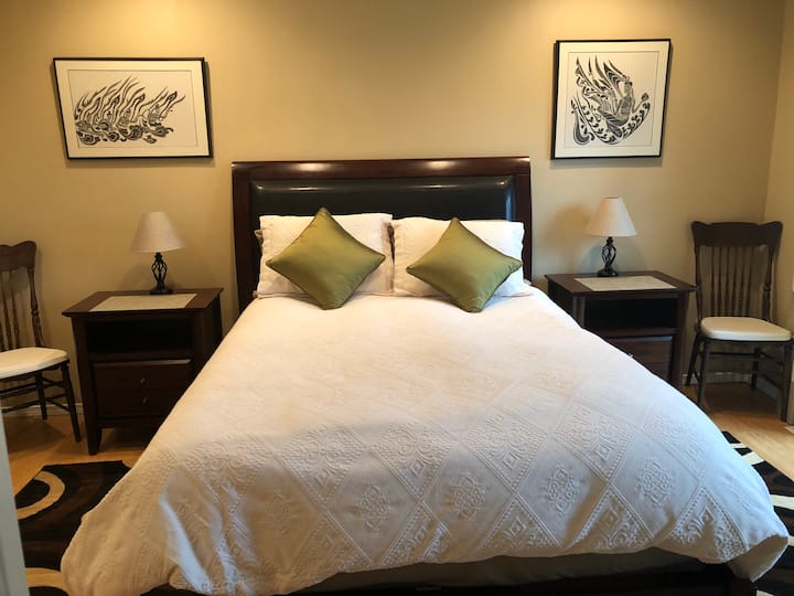 Queensize-Bett mit Beistelltischen mit iPhone-Ladegeräten.