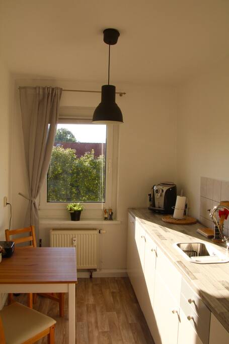 Küche mit zwei Herdplatten, Kühlschrank und Kaffeevollautomat