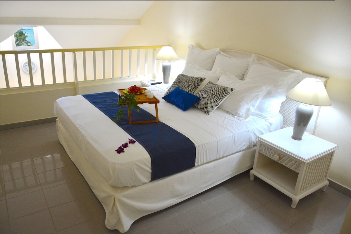 חדר שינה ראשי עם מיטת קינג סייז ונוף ים קטן למעלה 