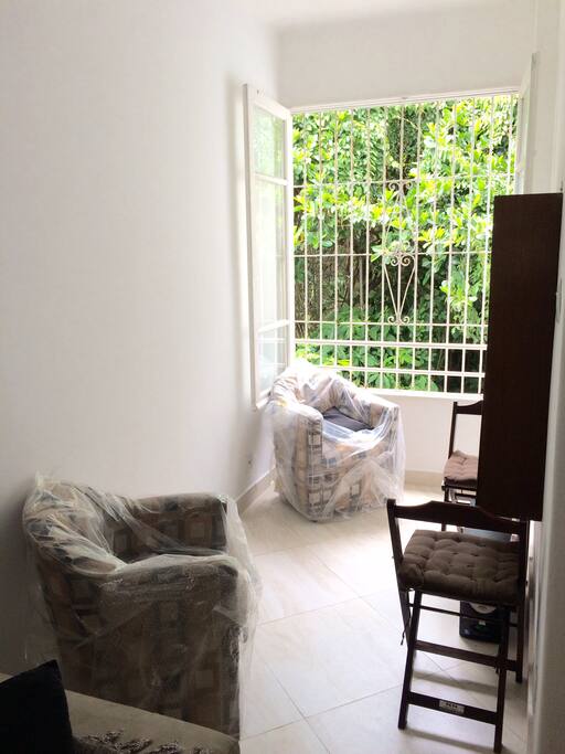 Espaço da sala com janela de frente para belas árvores, onde deixa o ambiente super bem ventilado.
