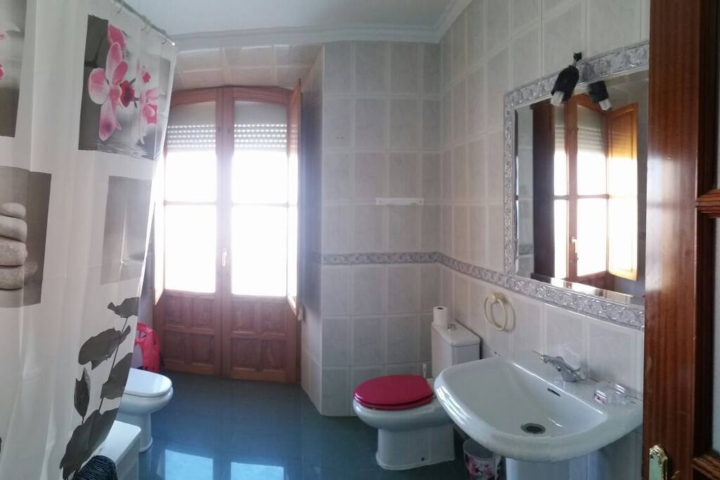 Amplio cuarto de baño con bañera y balcón al exterior