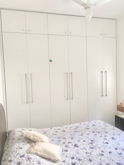 Quarto casal com ar condicionado e ventilador