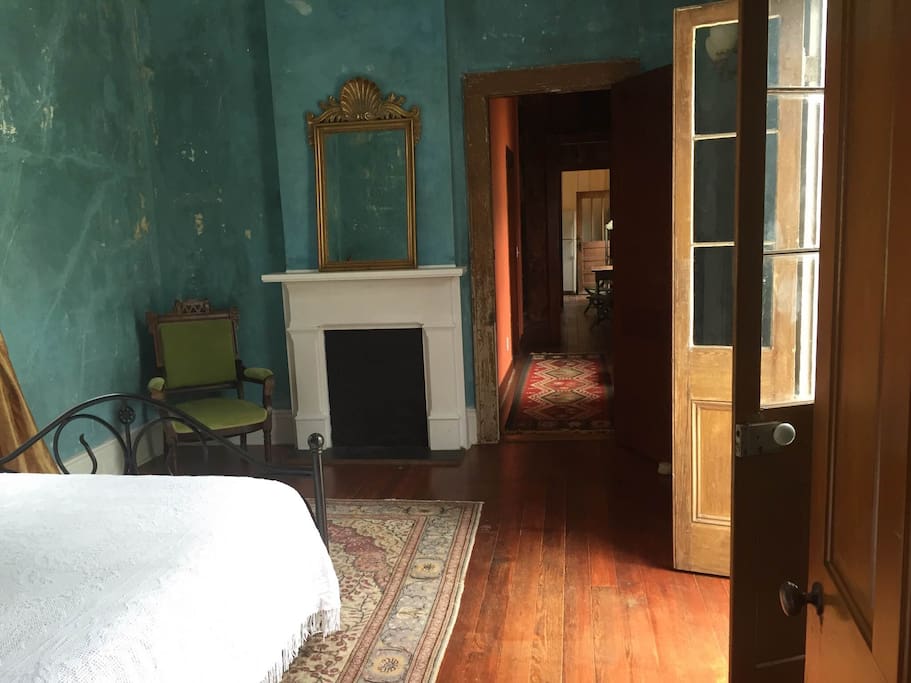 Bedroom opens onto side porch and connects to back house via center hall.
