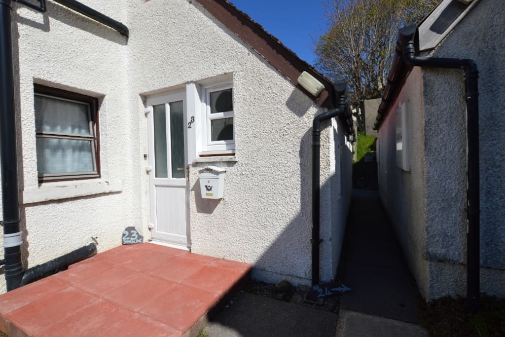 Walk through this passage to rear of building - door to the left at back.