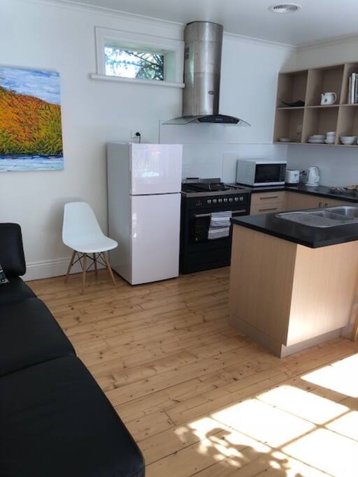 The kitchen is well equipped with large stove, microwave, dishwasher, refrigerator, coffee machine and island bench.
