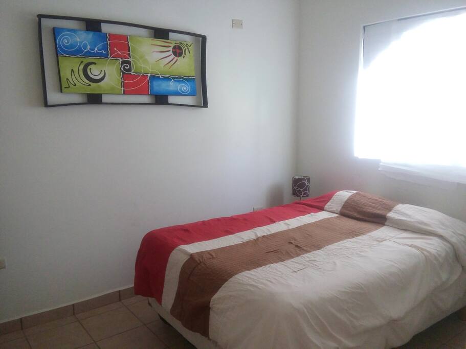 Cama matrimonial, ventilador y escritorio con silla