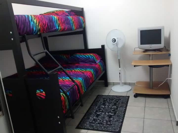 ห้องนอนพร้อมเตียงคู่และเตียงเดี่ยวสองชั้นตู้เสื้อผ้าขนาดใหญ่พัดลมโต๊ะรีดผ้าพื้นที่ทำงานพร้อมจอภาพที่มีทางเข้า VGA เพื่อเชื่อมต่อแล็ปท็อปของคุณและหน้าต่างพร้อมมุ้งกันยุง