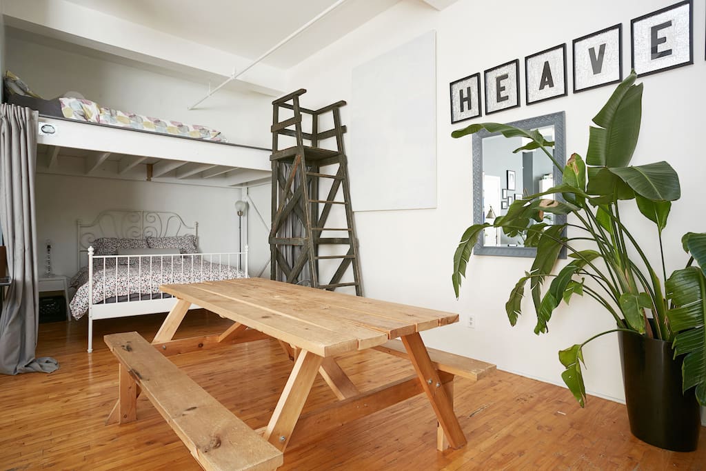 Two queen-sized beds; the second bed is on a raised platform accessible by stairladder.