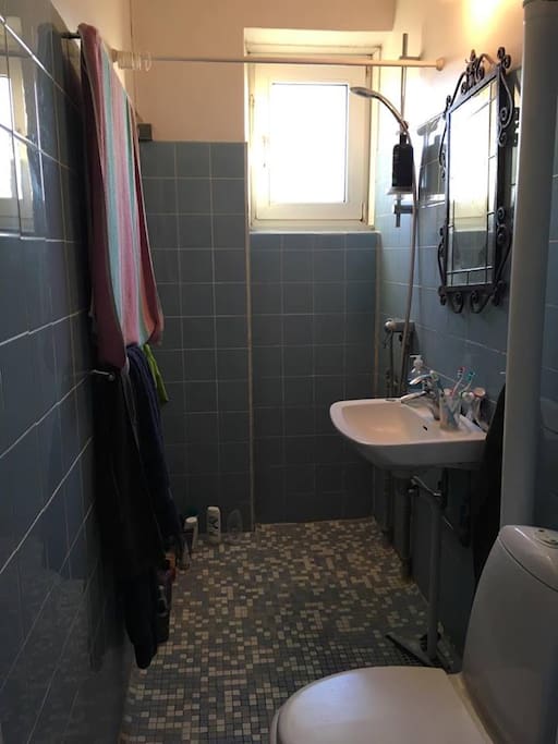 Bathroom with included towels, small window and closing door.