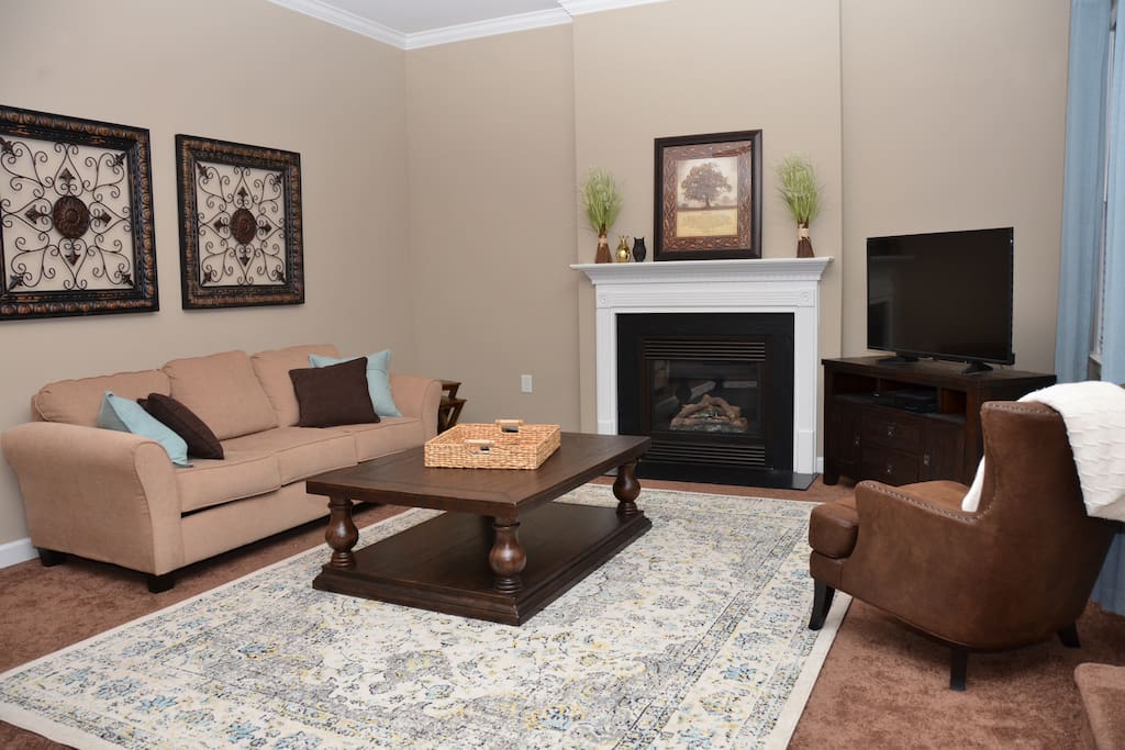 Living room with gas fireplace, ceiling fan and HD TV with Cable DVR.