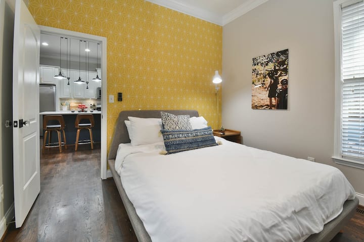 Modern guest room with Queen bed off of kitchen
