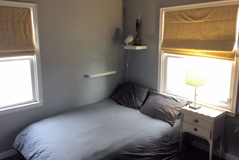 The main bedroom has a full bed and homemade blackout shades.