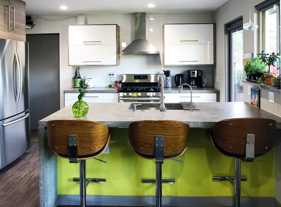 Newly updated kitchen with open layout, concrete countertops, gas range, filtered water, and comfy seating. Large sink, filtered drinking water, hidden trash and dishwasher.