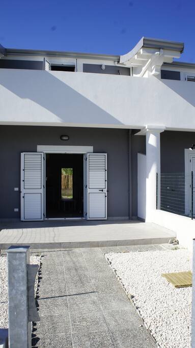Yard with solar shower and entrance to the apartment