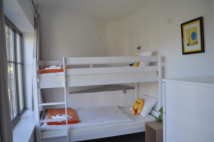 Liebevoll eingerichtetes Kinderzimmer mit Hochbett und Bildern von Keith Haring und Mirò