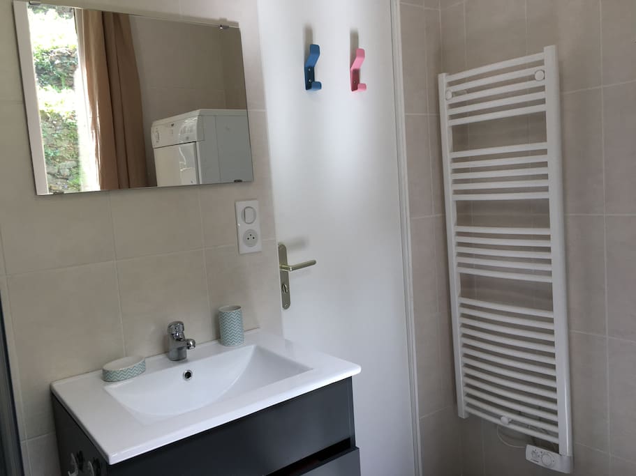 Salle de bain moderne et fonctionnelle équipée d'un lave-linge et d'un sèche-linge. Un chauffe serviette est toujours le bien venu pour le matin!
