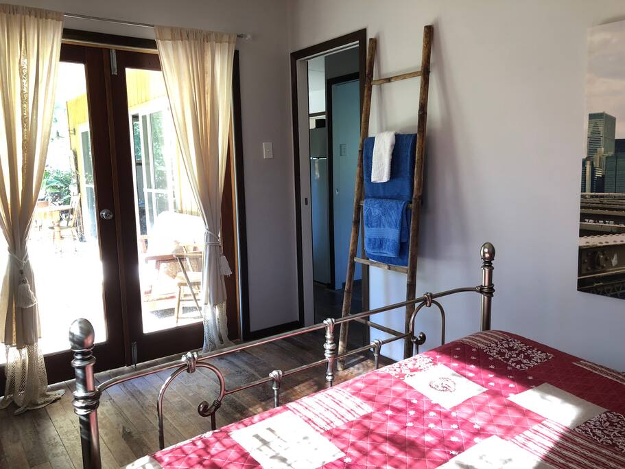 Main room. Queen bed. Chest of draws and hanging opening out onto verandah. This room has its own air conditioning.