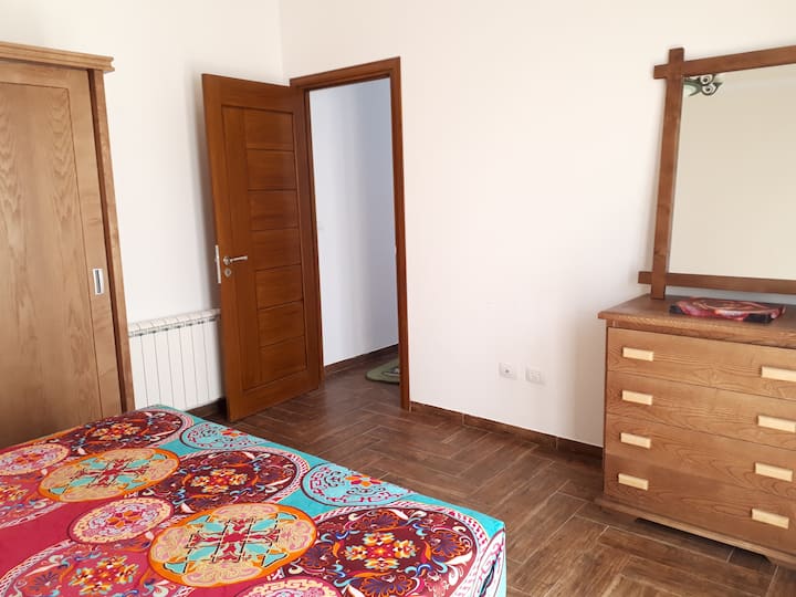 Spavaća soba s bračnim krevetom, ormarom, izravnim pristupom vrtu i privatnom kupaonicom pored spavaće sobe.