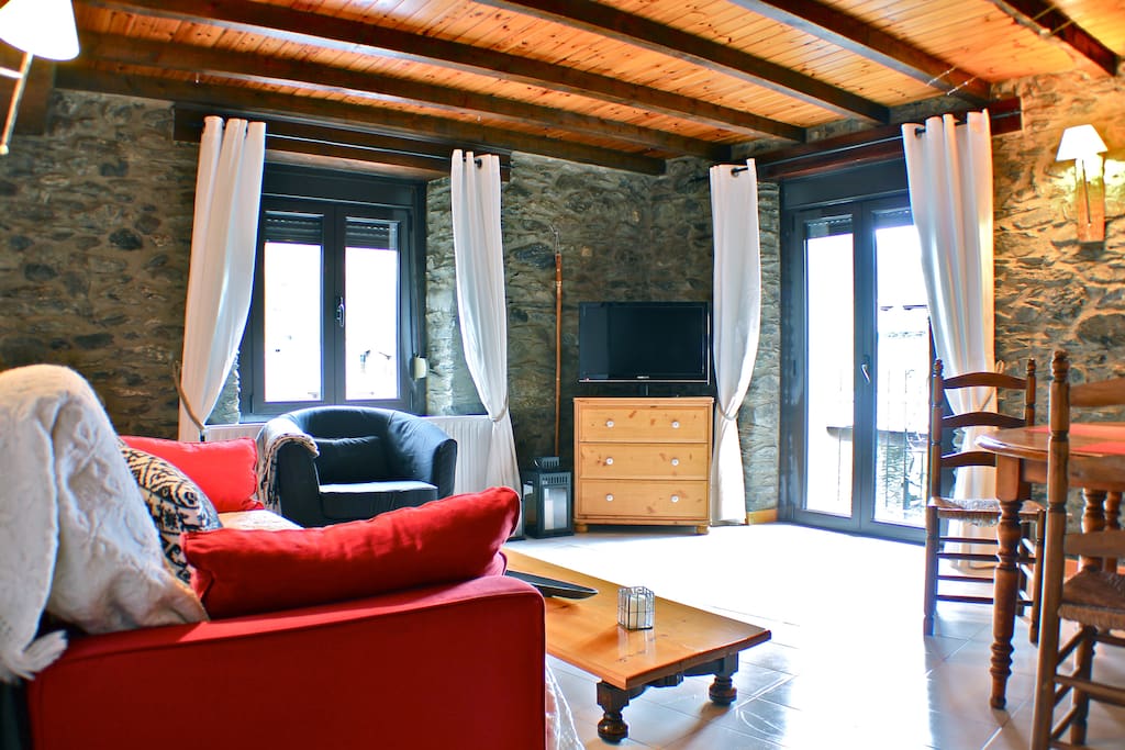 Living room and dinning with balcony, wood ceiling and stone walls